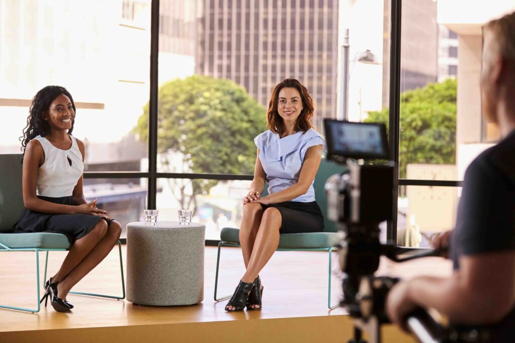 Zwei Frauen in einem Büro vor einer Kamera für ein Interview