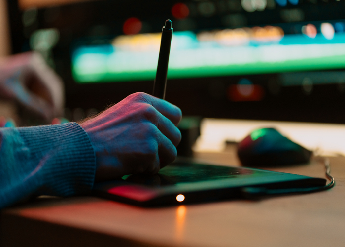 Male Video Editor hand Works with Footage or Video on His graphic panel of Personal Computer, he Works in Creative Office Studio or home. Neon lights