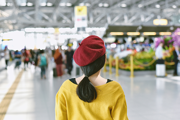 Asian woman standing in trade fair exhibition hall, Blurred back Asian woman standing in trade fair exhibition hall, Blurred background of large crowded people at big event with copyspace.