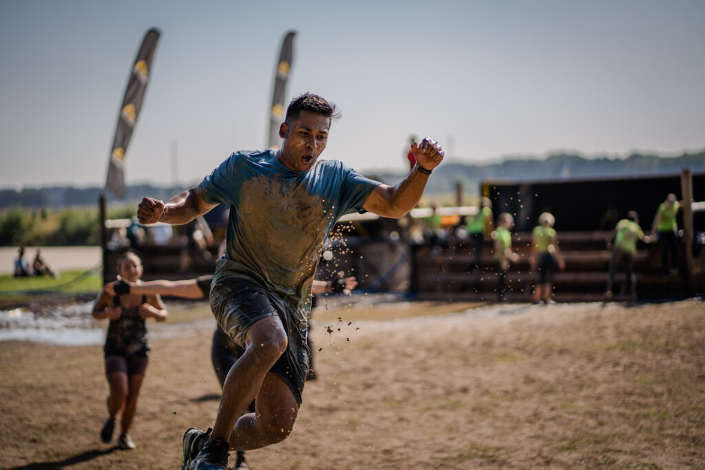 B-Roll-Aufnahmen von jungem Mann der in die Luft springt beim Mud Masters Weeze